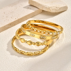 Golden stainless steel bangle set with shell motifs, evil eye design and zircon stones