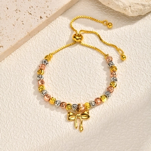 Detail of adjustable tricolor beaded bracelet with a delicate golden bow charm