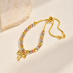 Detailed macro of tri-color faceted beads with a golden bow charm on adjustable chain