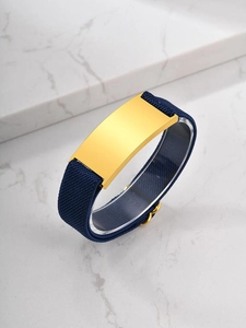 Detail of the golden rectangular metal plate on the dark blue elastic woven wristband