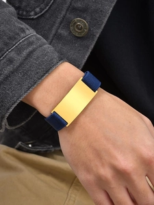 Close-up of golden metal plate on navy blue elastic woven bracelet for men