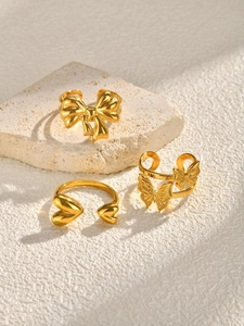 Detailed view of three gold-plated butterfly and heart-shaped adjustable open rings