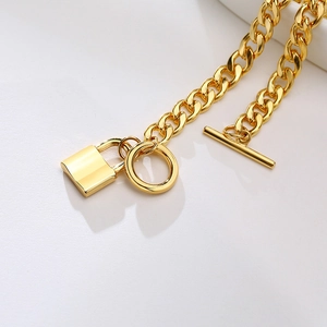 Detail of 7mm gold stainless steel Cuban chain bracelet with lock charm and toggle clasp
