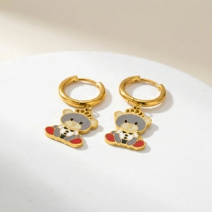 Golden stainless steel hoop earrings with cute crowned bear pendants on white display