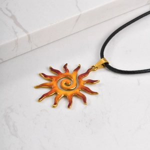Close-up of sun-shaped pendant with hammered texture and enamel gradient finish