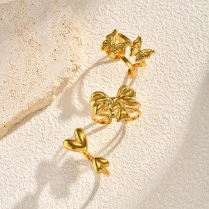 Detailed close-up of a three-piece gold ring set featuring butterfly and heart designs