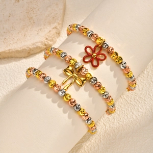 Three-tone beaded bracelet set with red enamel flower and golden bow charms