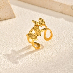 Detailed view of dual butterfly rings with brushed gold texture and adjustable bands