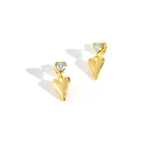 Detailed macro view of heart-shaped gold earrings with sparkling zircon inlay
