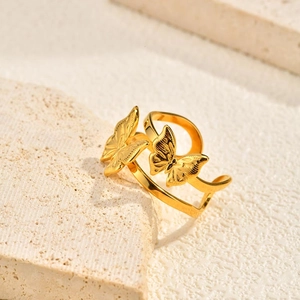 Macro detail of the golden double butterfly charms on a layered adjustable open ring