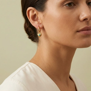 Detail of vintage heart earrings with blue turquoise inlay on elegant model