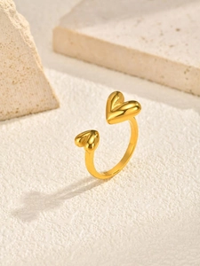 Detailed close-up of a minimalist golden heart-shaped open ring with 3D texture