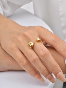 Detailed view of an adjustable gold stainless steel ring with two heart motifs on a hand