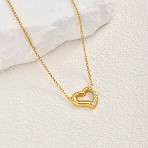 Collier cœur doré en acier inoxydable avec cinq zircons brillants sur une chaîne croisée