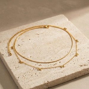Détail du collier double rang doré avec pendentifs nœuds et chaîne serpent ajustable