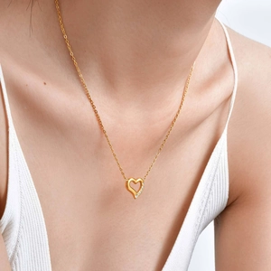 Détail du collier pendentif cœur doré avec pierres de zircon sur le cou d'un mannequin