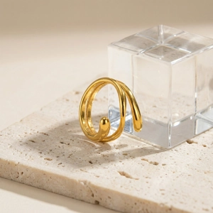 Close-up of golden multi-layer spiral ring with polished finish on stone background