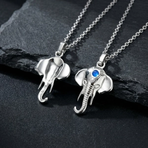 Macro detail of silver elephant pendants with blue gemstone inlay on stone texture