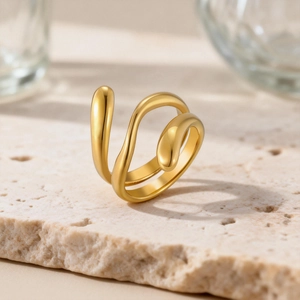 Macro shot of minimalist gold layered water drop ring on a textured stone surface