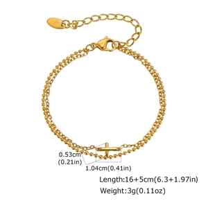Vista dettagliata del bracciale dorato a due strati con croce, marchio K18 e moschettone