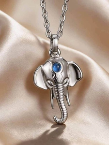 Macro detail of elephant pendant in silver steel with blue gemstone on satin