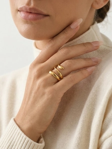 Macro detail of a gold spiral multi-layer ring on model finger with high metallic luster
