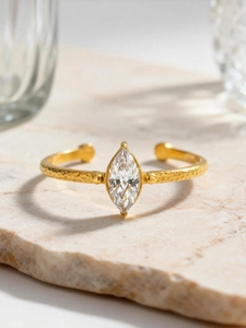 Macro detail of gold marquise cut zircon ring with handcrafted hammered texture finish