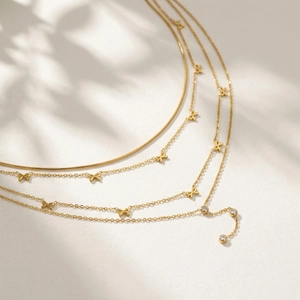 Collier multi-rangs doré élégant avec nœuds et pendentifs en cristal sur chaînes serpent