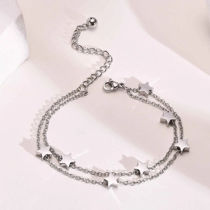 Detail of silver double-layered star chain bracelet with polished star charms and lobster clasp