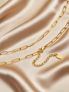 Macro shot of gold paperclip chain link with lobster clasp and K18 hallmark tag