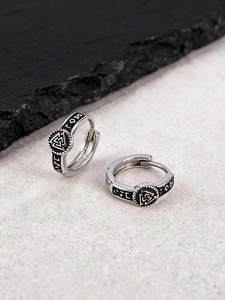 Macro view of men's punk Valknut Viking earrings with black oil drip runic engravings