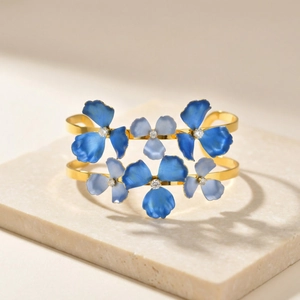 Double-row gold cuff bracelet with blue enamel flowers and sparkling zircon accents