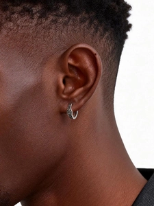 Close-up of a silver punk viking hoop earring with nordic runes on a male model