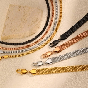 Close-up of four-color stainless steel mesh bracelets with lobster clasps on stone