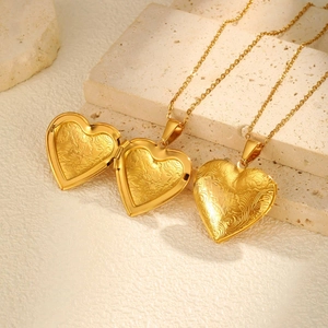 Detailed relief of heart-shaped stainless steel locket showing floral engraved pattern