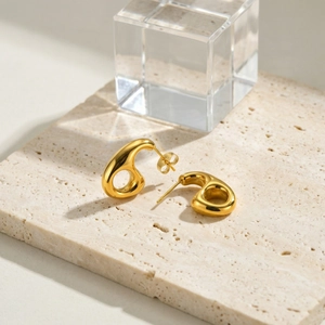 Boucles d'oreilles dorées géométriques évidées au design abstrait de goutte polie