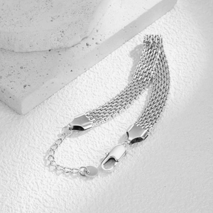 Detail view of silver mesh chain bracelet showing three layers and lobster clasp mechanism