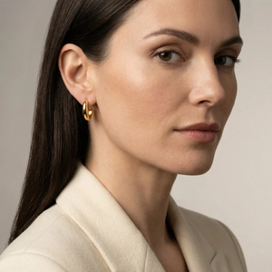 Élégantes boucles d'oreilles créoles dorées épaisses pour femmes portées par un mannequin
