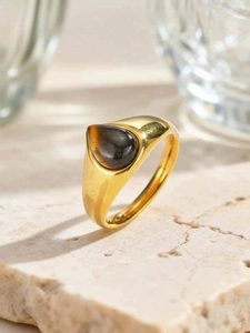 Vue détaillée d'une pierre œil de tigre en forme de goutte sur une bague dorée polie