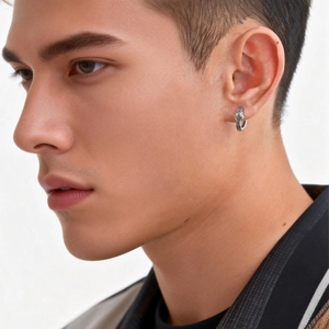Detail of silver viking tiger head earring with retro engraving on male model's ear