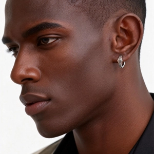 Close-up of men's silver viking hoop earring with intricate leaf engraving on earlobe