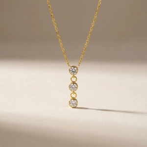 Collier minimaliste en acier inoxydable doré avec trois pierres de zircone verticales