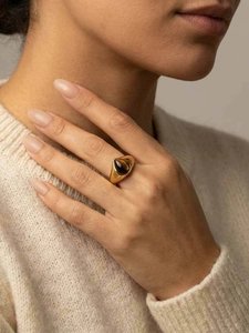 Vue détaillée d'une bague vintage dorée ornée d'une pierre œil de tigre en forme de goutte