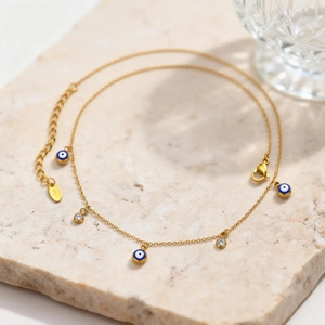 Détail du collier avec œil protecteur plaqué or 18 carats sur fond de marbre blanc