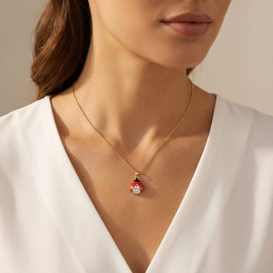 Détail d'une femme portant le petit pendentif coccinelle en or avec émail rouge et zircon