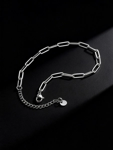Macro detail of stainless steel paperclip chain anklet with lobster clasp and extension
