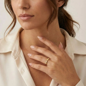 Exquisite gold floral open ring with zircon stones shown on model's finger
