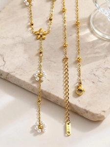 Dettaglio della collana a fiori dorati con perle e petali in metallo spazzolato K18