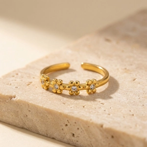 Elegant gold flower open ring with sparkling cubic zirconia on a natural stone base