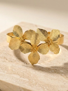 Vue macro détaillée du bracelet fleur doré avec textures de pétales sur pierre